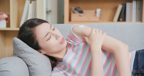 Woman holding her injured shoulder