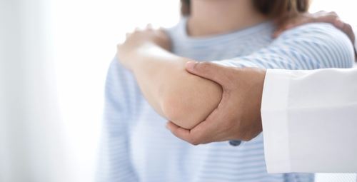 doctor holding a patients arm in the upright position