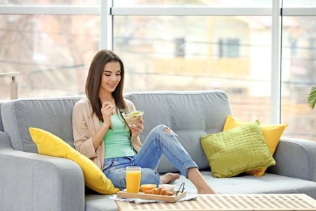 female sitting on couch eating