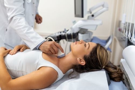 doctor doing an ultra sound on a woman's neck